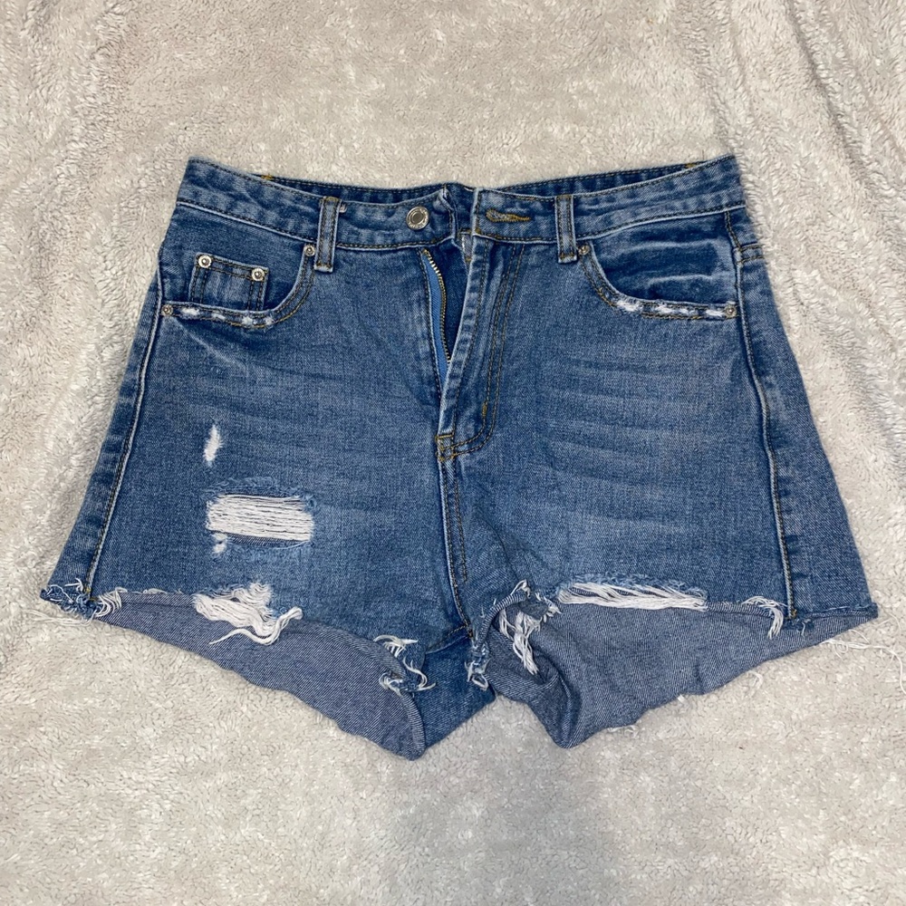 Medium wash. Distressed denim jeans